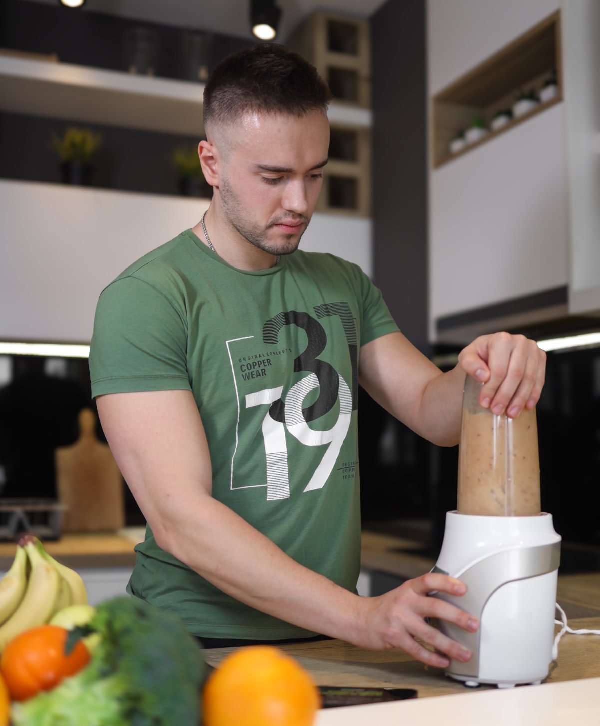 Muškarac priprema proteinski šejk u blenderu – zdrav napitak za oporavak posle treninga.